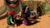 FILE - People rest next to shelters at the Zamzam camp for internally displaced persons near El Fasher in North Darfur, Feb. 4, 2015.
