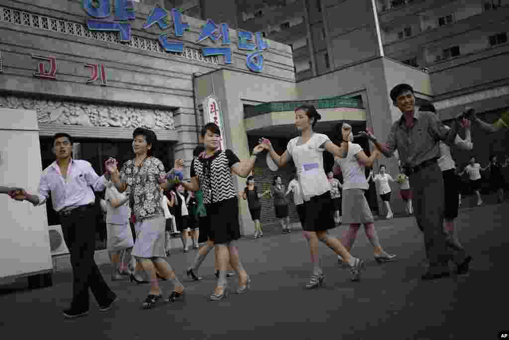 지난 7월 27일 평양에서 한국전 정전 61주년 기념 행사가 열린 가운데, 주민들이 춤을 추고 있다.