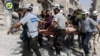 Sept. 21, 2016, file photo, provided by the Syrian Civil Defense White Helmets, rescue workers work the site of airstrikes in the al-Sakhour neighborhood of the rebel-held part of eastern Aleppo, Syria.