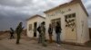 Members of the Kurdish People's Protection Units (YPG) chat together as they stand in front of a base, that used to be for Islamist Syrian rebel group Jabhat al-Nusra, after capturing it from them in Al-Rmelan, Qamshli province, Nov. 11, 2013.