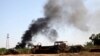 Smoke rises from the Brigade Qaqaa headquarters, a former Libyan Army camp known as Camp 7 April, following clashes between rival militias at the Sawani road district, Aug. 24,2014.