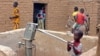 FILE - A child pumps water in the northern town of Kouroume, Mali, in May 2015. A UN envoy warns that the up to 41 million young people in the Sahel are at risk of radicalization.