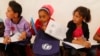 FILE - Syrian refugee children attend an English lesson inside a makeshift school tent during a visit by UNICEF Executive Director Anthony Lake.
