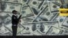 A security guard walks past a montage of old U.S. dollar bills outside a currency exchange bureau ahead of a scheduled State visit by the U.S. President Barack Obama in Kenya's capital Nairobi, July 23, 2015. 
