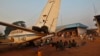A family displaced by inter-communal violence in Central African Republic sits near a plane in a camp for displaced persons at Bangui M'Poko International Airport, Feb. 20, 2014.