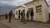 Members of the Kurdish People's Protection Units chat in front of a base captured from an Islamist Syrian rebel group in Al-Rmelan, Qamshli province. 