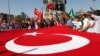 Demonstrators wave a huge national flag as they shout slogans in support of the Turkish military in central Istanbul, June 24, 2012.