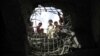 FILE - Boys look through a hole made by a Saudi-led airstrike on a bridge in Sanaa, Yemen, March 23, 2016. 