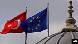 FILE - Flags of Turkey and the European Union are seen over the dome of a mosque in Istanbul, Turkey, Oct. 4, 2005. 