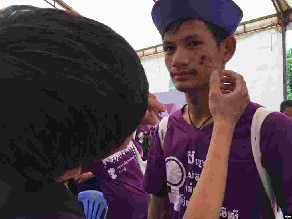 ក្រុមយុវជនកំពុងចូលរួមក្នុងយុទ្ធនាការ «ទីក្រុងមានសុវត្ថិភាពសម្រាប់ស្ត្រី» ជាលើកទី៤ ដោយមានការគូរមុខ បង្ហាញពីការគាំទ្រឲ្យបញ្ឈប់ហិង្សាលើស្រ្តី ក្នុងបរិវេណសាលាមធ្យមសិក្សាគរុកោល្យ មត្តេយ្យមជ្ឈិម នៅថ្ងៃទី៣០ ខែកក្កដា ឆ្នាំ២០១៧។ (កាន