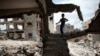 A Palestinian boy plays amid the rubble of his family's former house which was destroyed during the 50-day war between Israel and Hamas militants in the summer of 2014, in the eastern Gaza City Shujaiya neighborhood, May 11, 2015,.